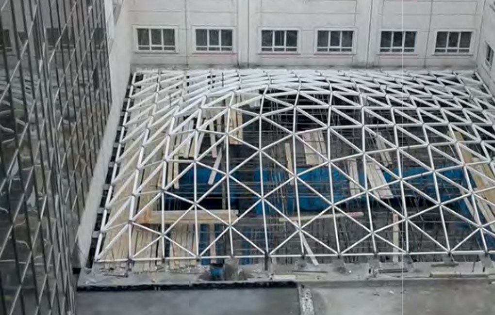 White tubular space-frame atrium skylight under construction